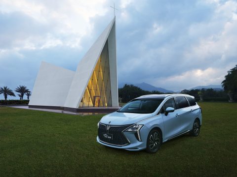 Forthing M4 PHEV parcat pe gazon, lângă o capelă modernă