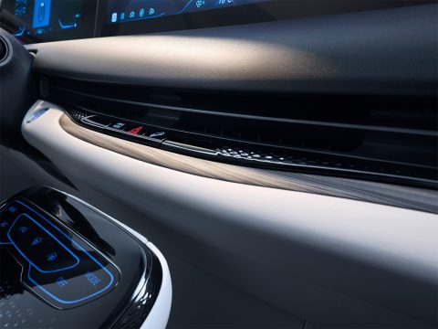 Detaliu al planșei de bord, cu inserție decorativă și comenzile climatizării
